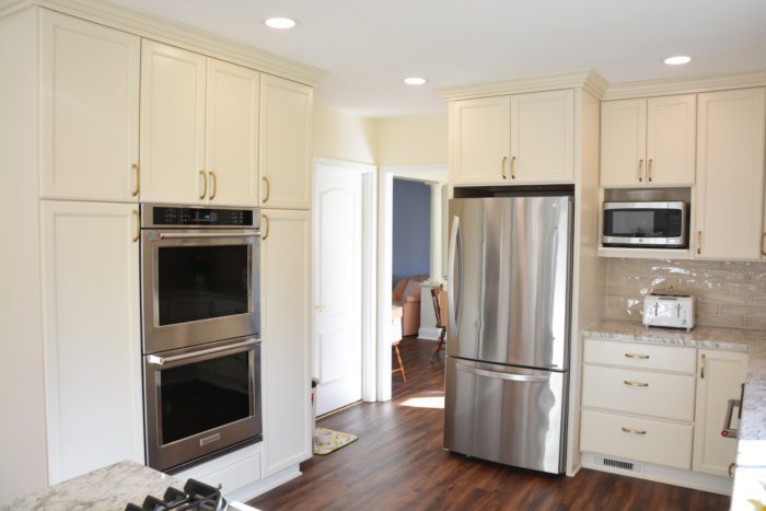 View of stainless fridge and white cabinets